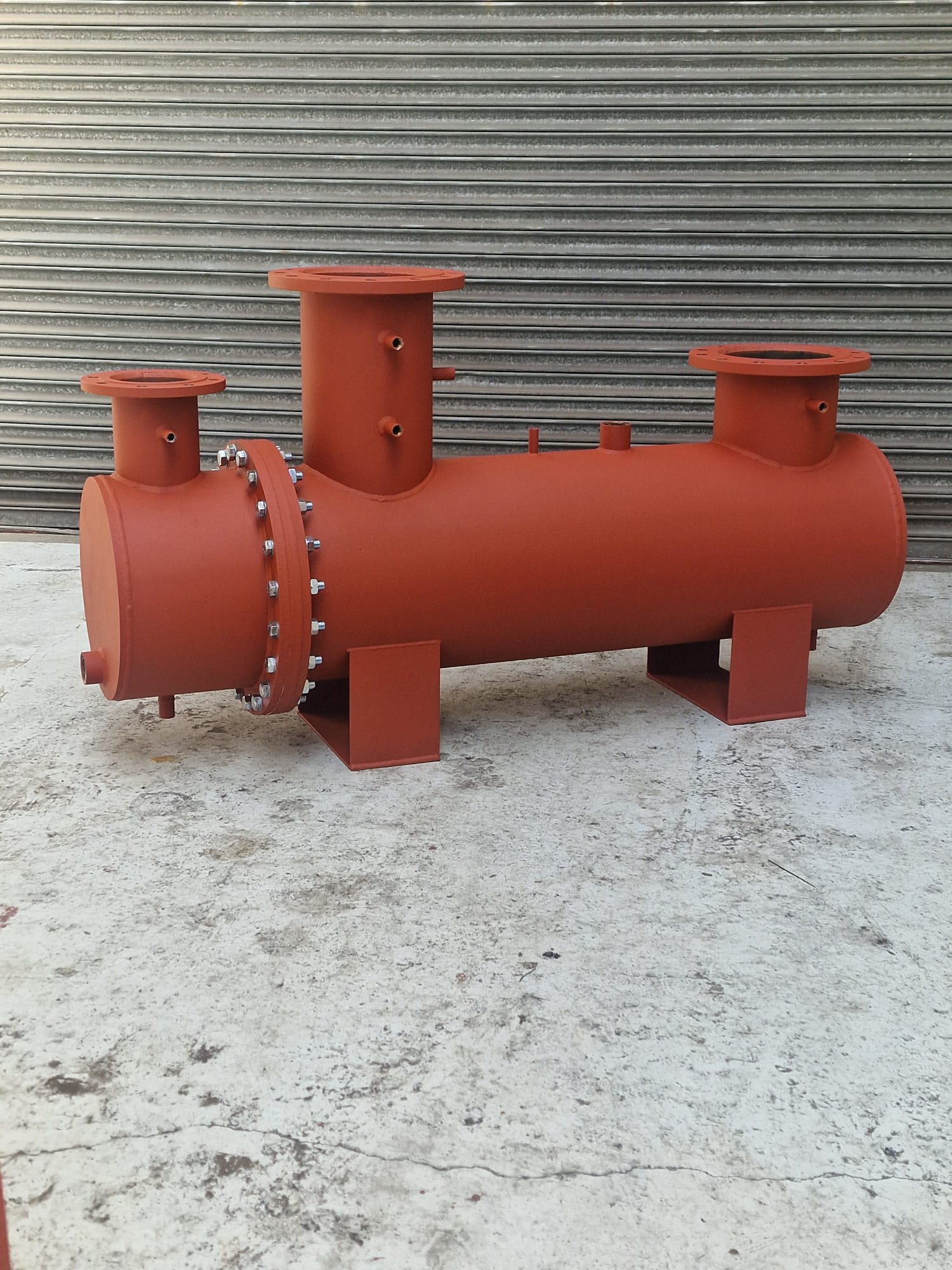 Red painted carbon steel pressure vessel manifold with flanged nozzles fabricated in the R2 workshop