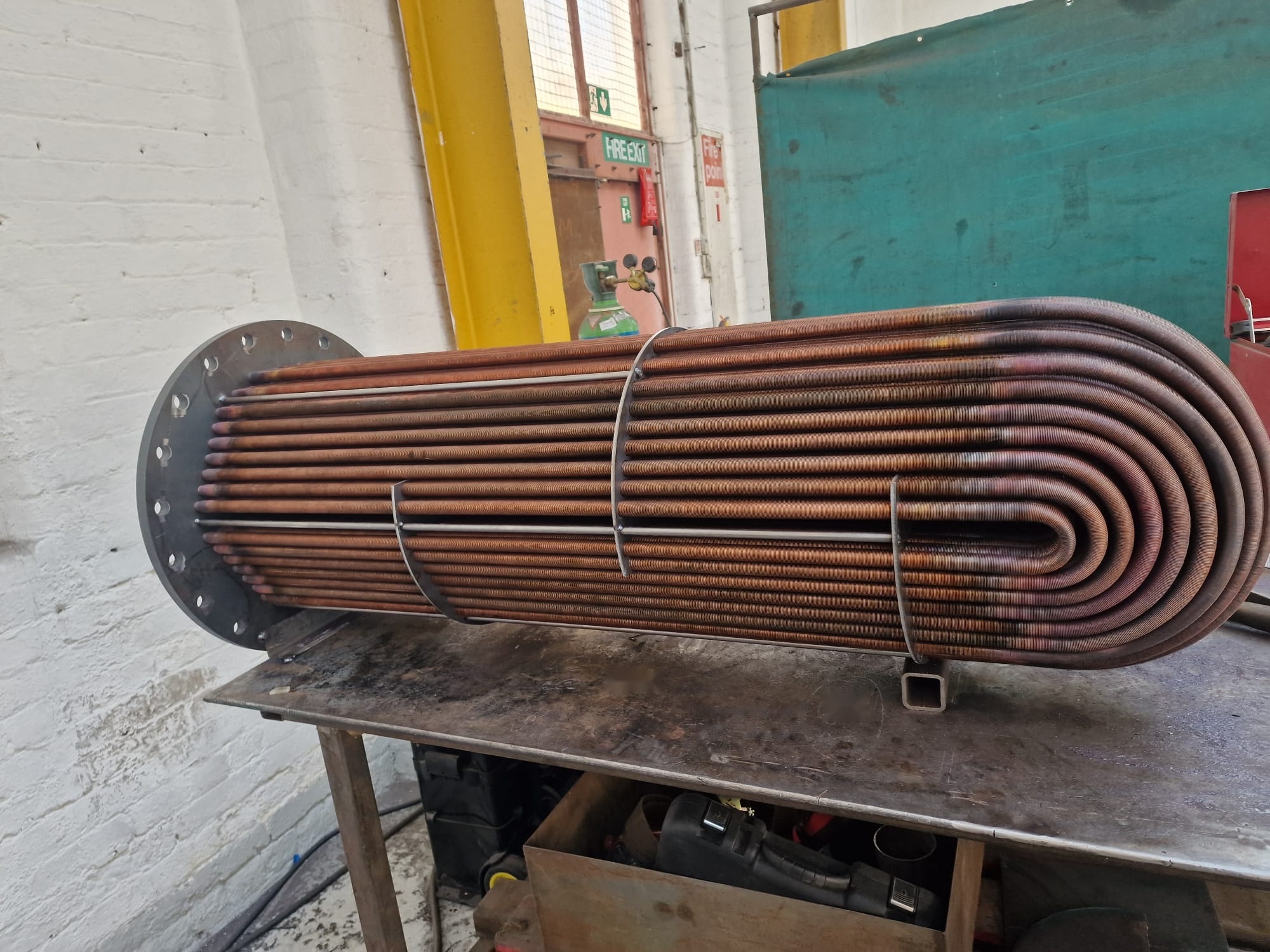 Stainless steel heat exchanger tube bundle on a workshop bench