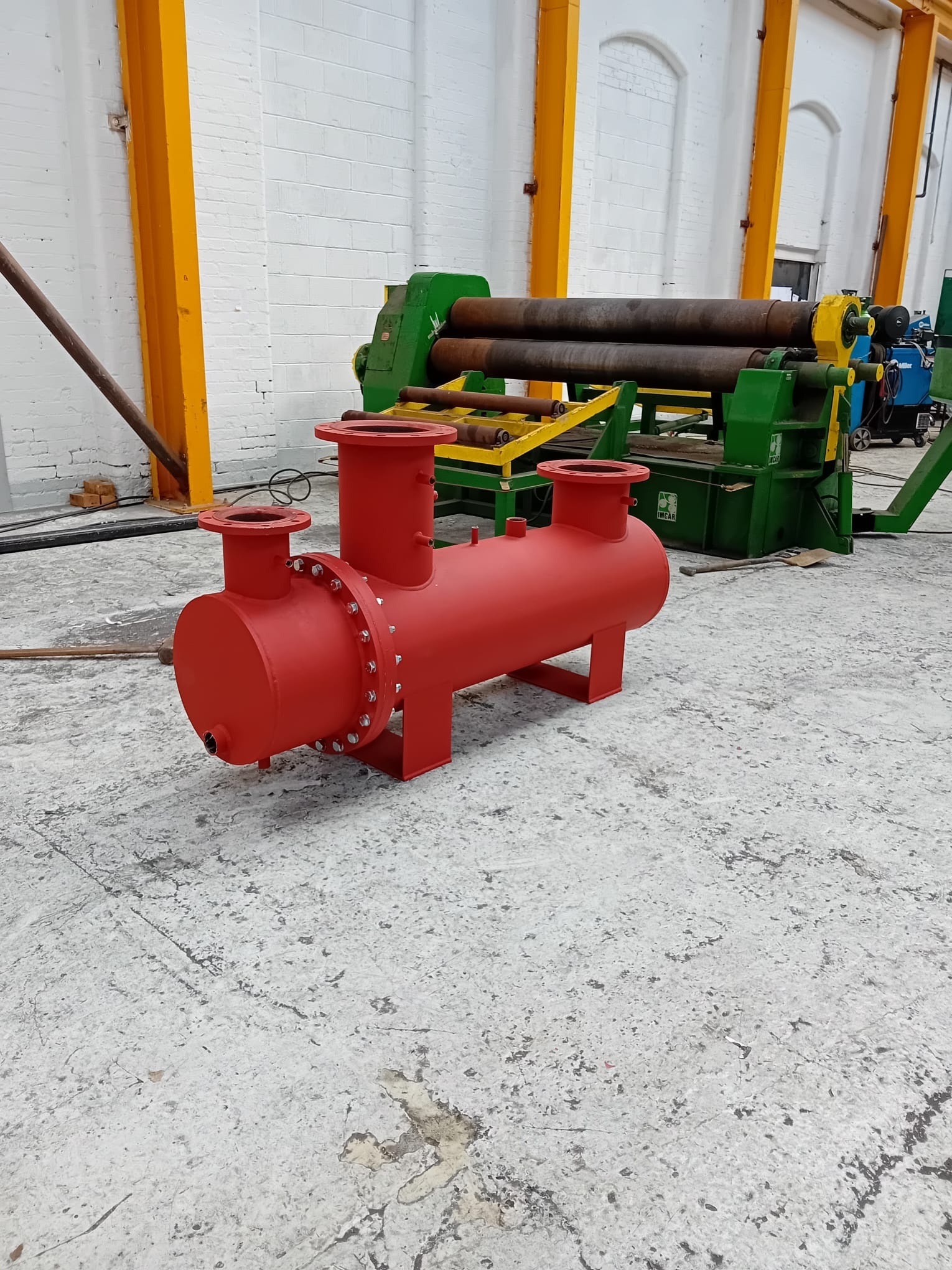 Red carbon steel pressure vessel with flanged nozzles in the R2 workshop